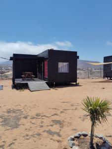 a black house in the middle of a desert at Cabañas Guayacanes in Coquimbo