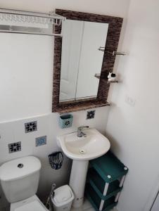 a bathroom with a toilet and a sink and a mirror at Cabañas Guayacanes in Coquimbo