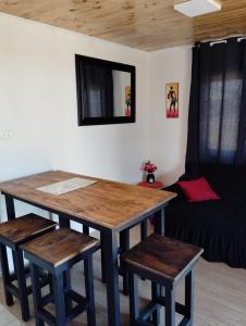 uma mesa e bancos num quarto com um sofá em Cabañas Guayacanes em Coquimbo