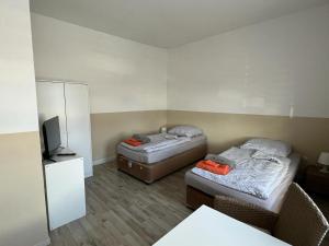 Cette petite chambre comprend deux lits et une télévision. dans l'établissement MWM Gästehaus-Zimmervermietung, à Meine