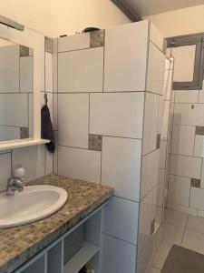 Baño blanco con lavabo y espejo en Jolie maison individuelle dans l’extrême sud, en Monacia-d'Aullène