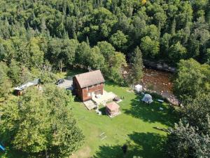 uma vista aérea de uma casa na floresta em Domaine de la rivière Montmorency, chalet luxueux em Sainte Brigitte de Laval
