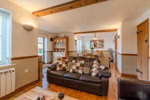 a living room with a couch and a kitchen at Moorhens in Somerford Keynes