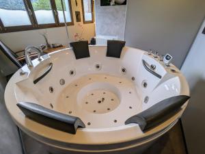 La salle de bains est pourvue d'une baignoire et d'un lavabo. dans l'établissement Roulotte cosy avec kitchenette, ruisseau apaisant et espace bien-être, nuit insolite à Ferdrupt - FR-1-589-444, à Ferdrupt 27 autres photos