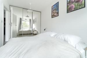 una camera con letto bianco e specchio di Apartament Chopina - Unique Apartments a Stettino