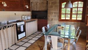 a kitchen with a glass table and a stove at Casa en condominio in El Calafate +13 photos