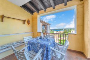 comedor con mesa y sillas y ventana grande en Lussuosa Dimora Vista Mare con Piscina e Spiaggia a 300 MT, en Liscia di Vacca