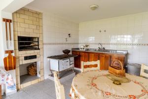 uma cozinha com uma mesa, um lavatório e um fogão em Encantadora casa em Campos do Jordão MAJ083 em Campos do Jordão