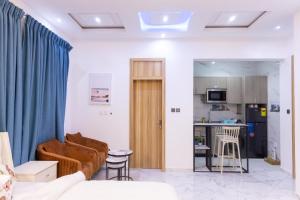 Una sala de estar con un sofá y una cocina. en Cozy Studio Apartment, East Airport, en Accra