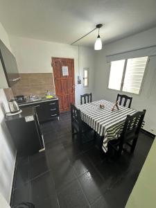 a kitchen with a table and chairs and a kitchen with a refrigerator at Departamentos Crisol in San Fernando del Valle de Catamarca