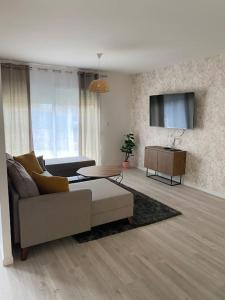 a living room with a couch and a tv at Villa by Nesma in Châtellerault