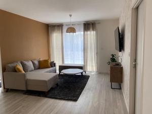 a living room with a couch and a tv at Villa by Nesma in Châtellerault