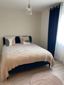a bedroom with a large bed with blue curtains at Villa by Nesma in Châtellerault +11 photos