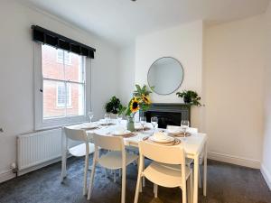 a dining room with a table with chairs and a mirror at City Centre 3-Bed Townhouse - 500m from Cathedral - Ideal for Families - Sleeps 6 in Canterbury