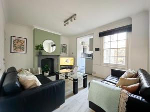 a living room with two couches and a fireplace at City Centre 3-Bed Townhouse - 500m from Cathedral - Ideal for Families - Sleeps 6 in Canterbury