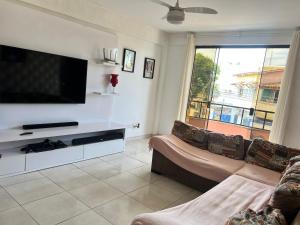 sala de estar con sofá y TV de pantalla plana en Bella Hospedagem no CENTRO De ARRAIAL DO CABO, en Arraial do Cabo