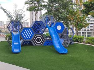 un parque infantil con un tobogán azul en el césped en Seaview Infinity Pool/ 40th/ 10pax/ 3Rooms 2Carpark, en Jelutong
