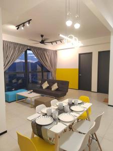 sala de estar con mesa, sillas y sofá en Seaview Infinity Pool/ 40th/ 10pax/ 3Rooms 2Carpark, en Jelutong