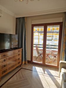 a living room with a television and a sliding glass door at Apartamento Centro Marbella in Marbella