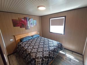 1 dormitorio con 1 cama en una habitación pequeña en Casita del Cerro en Castro