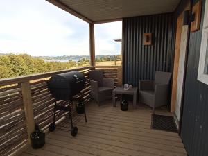 a balcony with chairs and a grill and a table at Casita del Cerro in Castro