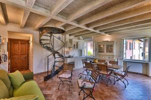 a living room with a spiral staircase and a table and chairs at Appartamento Al Porto Vecchio - Rebomaholidays in Bogliaco