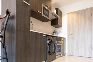 een keuken met een wasmachine en een magnetron bij Modern Studio Apartment, Lennox in Accra