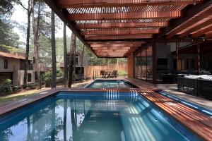 an outdoor swimming pool with a pergola over it at Casa con alberca y jacuzzi in Avándaro