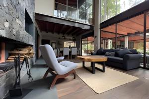a living room with a couch and a chair and a table at Casa con alberca y jacuzzi in Avándaro