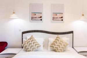 een slaapkamer met een wit bed met kussens bij Modern Studio Apartment, Lennox in Accra