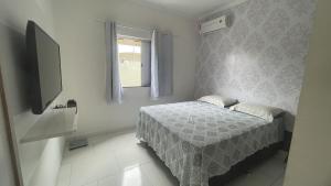 a small bedroom with a bed and a window at Apto próximo do Centro de Porto in Porto Seguro