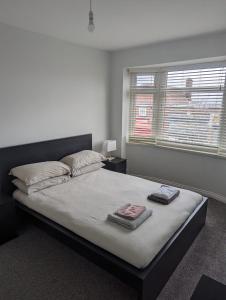 HeeleyにあるModern 3 bedroom home, close to City Centre and Peak Districtのベッドルーム1室(大型ベッド1台、タオル2枚付)