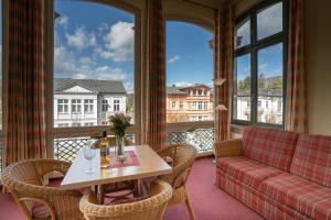 ein Wohnzimmer mit einem Sofa, einem Tisch und Stühlen in der Unterkunft Villa Stock Appartement mit großer Veranda in Heringsdorf