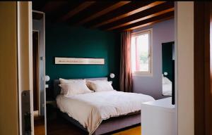 1 dormitorio con 1 cama con pared verde en Residence19ilborgo, en Asolo