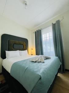 a bedroom with a large bed with a large window at Tafre Hospitality @ Stratford, Menlyn in Pretoria