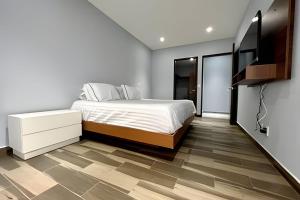 Schlafzimmer mit einem Bett und einem Flachbild-TV in der Unterkunft Departamento a 5 minutos de Anáhuac in Mexiko-Stadt