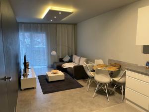 een woonkamer met een bank en een tafel bij Wenecjanska Comfort Apartment, free parking, self check-in 24h in Poznań