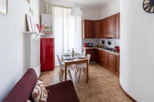 eine Küche mit einem Tisch und einem roten Kühlschrank in der Unterkunft Apt vicino alla metro Porta Romana • WiFi, Netflix in Mailand