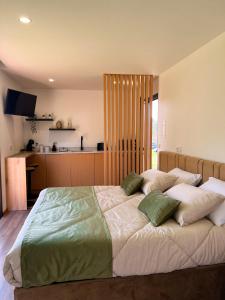 Un dormitorio con una cama grande con almohadas verdes y blancas en Quinta de Requeixo en Guimarães