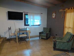 uma sala de estar com uma mesa e cadeiras e uma televisão em Casas de Campo El Rincón em San Antonio