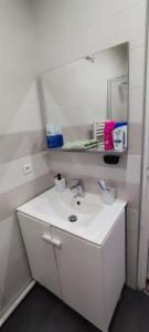 ein weißes Badezimmer mit einem Waschbecken und einem Spiegel in der Unterkunft Chambre#2 zen / logement partagé in Villeneuve-Saint-Georges