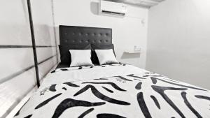 białe łóżko w białym pokoju w obiekcie Kost Harian Semarang Murah w mieście Semarang