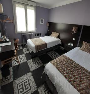 a hotel room with two beds and a window at Hotel Le Charleston in Le Mans