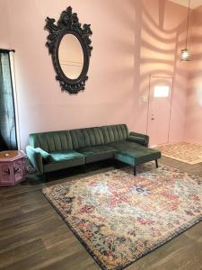 - un salon avec un canapé vert et un tapis dans l'établissement 5- Bed Pink house ( Close to Sports Center ), à West Monroe