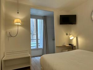 una camera d'albergo con letto e finestra di Hotel Little Regina a Parigi