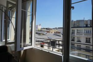 two windows in a room with a view of a building at Arc de Triomphe Apartment in Paris