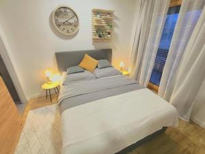 a bedroom with a large bed with a clock on the wall at Park Bôrik 4YOU & Free Parking in Žilina