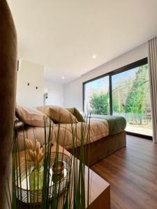 a living room with a couch and a large window at Quinta de Requeixo in Guimarães