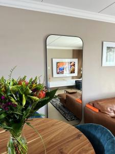 a living room with a table and a mirror at White Orchid Luxury Apartment in Chartwell