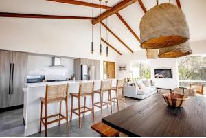 Il comprend une cuisine et un salon avec une table et des chaises. dans l'établissement CASA ROSA 49’ - Playa Venao Beach, à Playa Venao